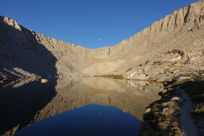 Moon reflecting on a calm Lake 4 with the trail running along the lake and heading up to Army Pass.
