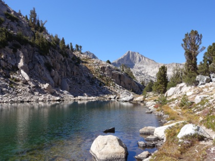 The trail follows the lake to the outlet as the water flows out and down to the next lake below.