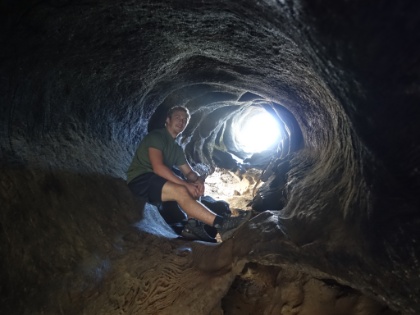 No, not a cave. Dustin is sitting in a fallen, hollowed-out Sequoia probably a couuple hundred feet long.