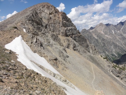The trail heading down a huge talus slope on the other side.