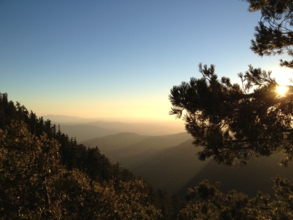 A hazy mountain view in the early evening as the sun is about to set.