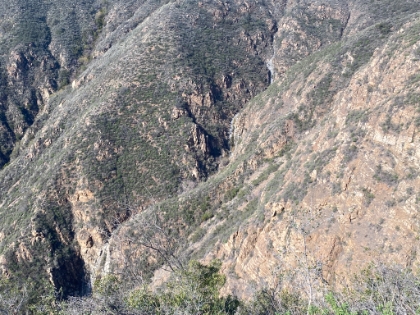 After going up and down multiple hills along the ridge, we finally get to the spot where the trail dives straight downhill into the canyon. Here we get the first view of the cascading falls to the left of Hot Spring Canyon Falls.