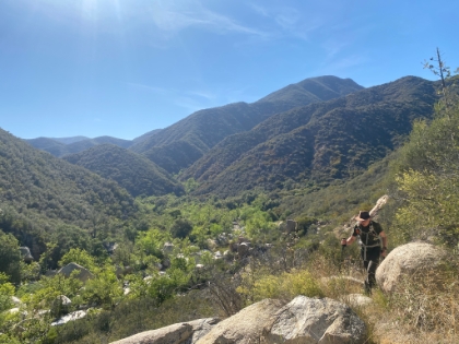 Dad heading up one of the many rolling uphills on the way back, with the creek and green canopy below.