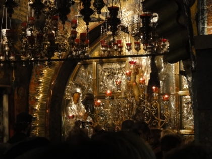 The Golgotha altar. Station XII, the Rock of the Calvery, is the spot at which Jesus was crucified. The top of the rock hill can be seen beneath glass on either side of the altar. Within the rock is a hole in which the cross was believed to have been raised. This area of the church is extremely crowded and difficult to get near.