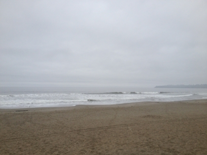 The Pacific Ocean. There are only a few people on this whole stretch of beach.