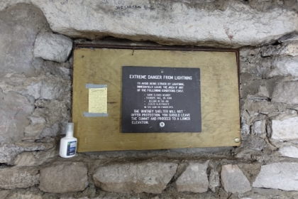 The sign in the cabin doesn't give me much confidence in staying on the summit for long. The dark clouds are already coming in, thunder in the distance has already started, and the first drops of rain are starting.