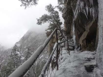 Heading across the ledge almost to the top. The railing is a little rickety, and I never fully trust it, especially when walking on ice. That's a drop of about 300' to the left. You can see that the trail is closed again at the top. You have to actually crawl under the railing to get past it.
