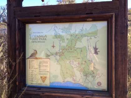 The trail rejoins the fire road at the trailhead for the Backbone Trail leading into Topanga State Park.