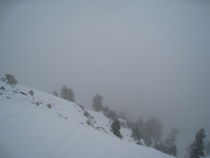 Once the trail leaves the obvious ridgeline, things start getting a lot tougher. This area of the trail was VERY hard to follow even with zero snow. Now it's completely covered in snow. I'm basically just guessing and wandering in a general direction at this point. Visibility is extremely low, so I can't see any of the peaks around me to get my bearings. I'm going by compass, map, and a couple glances at my iPhone GPS (the battery is almost dead, and I'm worried about the phone getting wet and frozen, so I use it sparingly). I double back many times. I slip and slide and crash land many times. This is the first point at which I start to really get worried and wonder whether I'm being stupid here. I don't take too many pictures during this stretch.